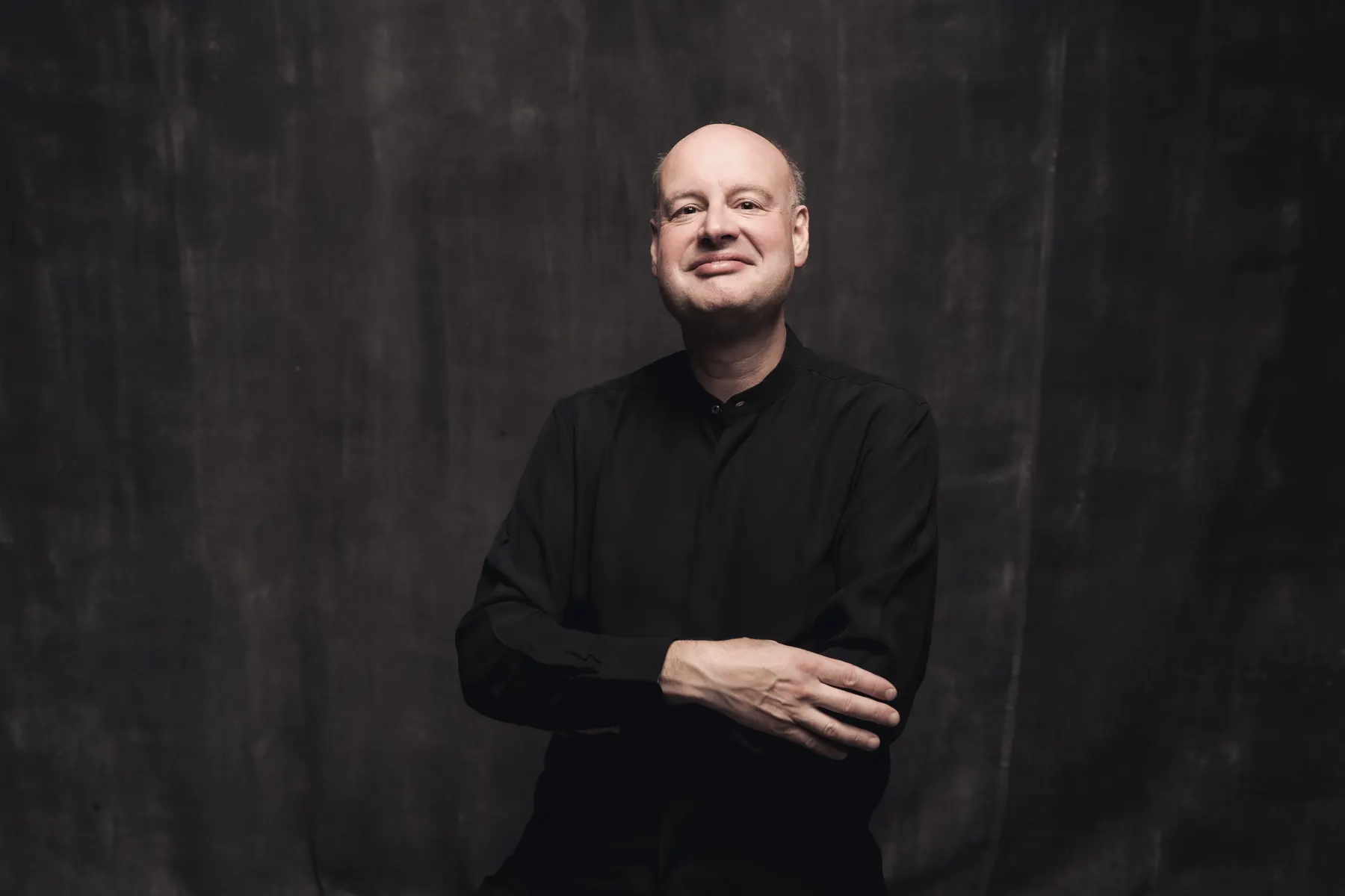 Stephen Layton, smiling, arms crossed